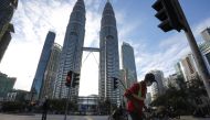 A street cleaner works in front of Petronas Twin Towers, amid the coronavirus disease (COVID-19) outbreak in Kuala Lumpur, Malaysia January 11, 2021. REUTERS/Lim Huey Teng