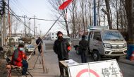 Volunteers stand at a checkpoint on a road leading into their village, following the coronavirus disease (COVID-19) outbreak, on the outskirts of Beijing near the provincial border with Hebei province, China January 12, 2021. REUTERS/Thomas Peter