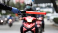 A police officer stops a rider at a roadblock as he enforces a lockdown due to the coronavirus disease (COVID-19) outbreak, in Kuala Lumpur, Malaysia January 13, 2021. Reuters/Lim Huey Teng