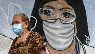 A woman wearing a face mask as protection against the coronavirus disease (COVID-19) walks past a mural dedicated to frontline workers, in Manila, Philippines, January 11, 2021. REUTERS/Lisa Marie David