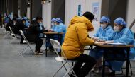 People fill forms before receiving a dose of a coronavirus disease (COVID-19) vaccine at a vaccination site, during a government-organized visit, in Beijing, China January 15, 2021. REUTERS/Carlos Garcia Rawlins