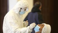 A health worker takes a swab from a man to be tested for coronavirus disease (COVID-19) in the town of Hasbaya, Lebanon, January 16, 2021. REUTERS/Aziz Taher
