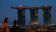FILE PHOTO: The Marina Bay Sands integrated resort lights up in tribute to the healthcare workers and people staying home to curb the spread of the coronavirus disease (COVID-19) outbreak in Singapore, April 10, 2020. REUTERS/Edgar Su/File Photo
