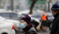 People wearing face masks following the coronavirus disease (COVID-19) outbreak are seen on a snowy day in Beijing, China January 19, 2021. REUTERS/Tingshu Wang