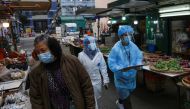 Medical workers in protective suits walk near the residential area at Jordan, after the expand of mandatory coronavirus disease (COVID-19) testing, in Hong Kong, China January 19, 2021. REUTERS/Tyrone Siu