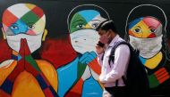 A man walks past a graffiti of people wearing protective masks amidst the spread of Covid-19 on a street in Navi Mumbai, India January 21, 2021. Reuters/Francis Mascarenhas