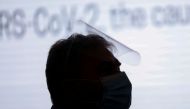 A man wearing a face mask and face shield is silhouetted during a press briefing at Philippine Red Cross in Mandaluyong City, Metro Manila, Philippines, January 25, 2021. REUTERS/Eloisa Lopez