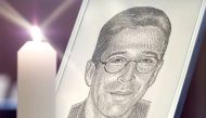 A portrait of the Wall Street Journal's reporter Daniel Pearl stands with a candle at the altar at Fleet Street's journalists chapel St Brides Church prior to a memorial service in London March 5, 2002. Reuters/Ian Waldie IW/NMB/File Photo