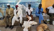 Men sit near a pelican as the spread of the coronavirus disease (COVID-19) continues, in Ouakam neighbourhood, Dakar, senegal January 22, 2021. REUTERS/Zohra Bensemra
