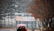 FILE PHOTO: Women wearing a mask as a measure to prevent contracting the coronavirus disease (COVID-19) walk under an umbrella as it snows in Seoul, South Korea, January 18, 2021. REUTERS/Kim Hong-Ji TPX IMAGES OF THE DAY/File Photo
