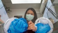 A healthcare worker takes off her protective gloves during proactive testing at the work place of migrant workers, amid the spread of the coronavirus disease (COVID-19) outbreak, in Samut Sakhon province, Thailand January 29, 2021. REUTERS/Soe Zeya Tun