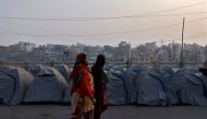 Women walk past rows of tents used by farmers who have gathered to protest against farm laws at Ghaziabad, India, January 28, 2021. Reuters/Danish Siddiqui