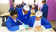 Students of Qatar Science and Technology Secondary School for Boys learning in a classroom. 