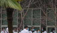 Chinese scientists and officials in lab coats wait at the Hubei Animal Epidemic Disease Prevention and Control Center during a visit of a team of the World Health Organization (WHO), tasked with investigating the origins of the coronavirus disease (COVID-