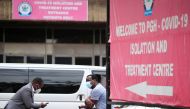 People sit beside banners outside a hospital during the coronavirus disease (COVID-19) outbreak in Harare, Zimbabwe January 28, 2021. Picture taken January 28, 2021. REUTERS/Philimon Bulawayo
