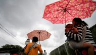 Women carrying children walk along a street affected by floods in Jakarta, Indonesia, February 8, 2021. REUTERS/Willy Kurniawan
