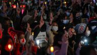 Demonstrators show the three-finger salute as they protest against Myanmar military coup, in Tokyo, Japan, February 11, 2021. REUTERS/Issei Kato