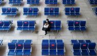 FILE PHOTO: A woman waits in the departure hall of Beijing South Railway station ahead of Lunar New Year celebrations following an outbreak of the coronavirus disease (COVID-19) in Beijing, China, February 10, 2021. REUTERS/Thomas Peter/File Photo
