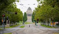 A person crosses an empty street on the first day of a five-day lockdown implemented in the state of Victoria in response to a coronavirus disease (COVID-19) outbreak in Melbourne, Australia, February 13, 2021. REUTERS/Sandra Sanders