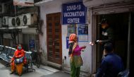 A man checks documents of a woman, outside a vaccination centre, in New Delhi, India, February 13, 2021. REUTERS/Adnan Abidi