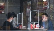 People sit in a restaurant behind plastic dividers as a measure against the sread of the coronavirus disease (COVID-19) in Hanoi, Vietnam, February 18, 2021. REUTERS/Thanh Hue