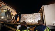 Workers offload pallets containing coronavirus disease (COVID-19) vaccine 