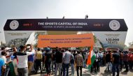Workers install a hoarding renaming the world's largest cricket stadium after Prime Minister Narendra Modi, as fans wait to enter before the start of the third test match between India and England in Ahmedabad, India, February 24, 2021. Reuters/Amit Dave
