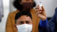 Sanitation worker Manish Kumar, who according to the officials is the first person in the country vaccinated against the COVID-19, looks at his dose of Bharat Biotech's COVAXIN at All India Institute of Medical Sciences (AIIMS) hospital in New Delhi, Indi