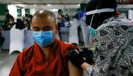 A monk reacts while receiving the first dose of China's Sinovac Biotech vaccine for the coronavirus disease (COVID-19) during the mass vaccination program for clergy at the parking lot of Grand Istiqlal Mosque in Jakarta, Indonesia, February 25, 2021. REU