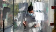 A man wearing a face mask and a face shield as protection against the coronavirus disease (COVID-19) enters a disinfection booth at a community quarantine checkpoint, in Pasay, Metro Manila, Philippines, February 25, 2021. Reuters/Lisa Marie David
