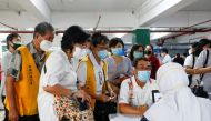 People talk to the officials before receiving the first dose of China's Sinovac Biotech vaccine for the coronavirus disease (COVID-19) during the mass vaccination program for clergy at the parking lot of Grand Istiqlal Mosque in Jakarta, Indonesia, Februa