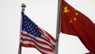 FILE PHOTO: Chinese and U.S. flags flutter outside the building of an American company in Beijing, China January 21, 2021. REUTERS/Tingshu Wang/File Photo
