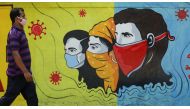 A man wearing a protective mask walks past a graffiti amidst the spread of the coronavirus disease (COVID-19) on a street in Navi Mumbai, India, March 8, 2021. REUTERS/Francis Mascarenhas