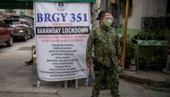 A police officer mans a checkpoint at a village under lockdown amid rising coronavirus disease (COVID-19) infections, in Manila, Philippines, March 12, 2021. REUTERS/Eloisa Lopez/File Photo