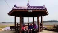 Residents dressed in purple clothing take a break at the Purple Island in Shinan, South Korea, March 9, 2021. Picture taken March 9, 2021. REUTERS/Daewoung Kim
