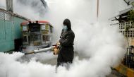 A worker in a hazmat suit disinfects a street as a preventive measure against the spread of coronavirus disease (COVID-19) at a village in Manila, Philippines, March 19, 2021. REUTERS/Lisa Marie
