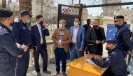 Men speak with police officers as Palestinians begin registering party lists for May parliamentary election, at the Palestinian Central Elections Commission's office in Gaza City March 20, 2021. REUTERS/Mohammed Salem