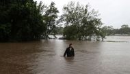 A man wades through floodwaters on a residential street near the swollen Nepean River as the state of New South Wales experiences widespread flooding and severe weather, in Sydney, Australia, March 21, 2021. REUTERS/Loren Elliott