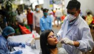 A healthcare worker collects a swab sample from a woman, amidst the spread of the coronavirus disease (COVID-19), at a local health centre, in New Delhi, India, March 25, 2021. REUTERS/Adnan Abidi