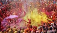 Men daubed in colours throw coloured powder at each other during Lathmar Holi celebrations, amidst the spread of the coronavirus disease (COVID-19), in the town of Nandgaon, in the northern state of Uttar Pradesh, India, March 24, 2021. REUTERS/K. K. Aror
