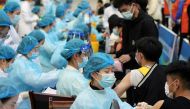 Medical workers inoculate students with the vaccine against the coronavirus disease (COVID-19) at a university in Qingdao, Shandong province, China March 30, 2021. Picture taken March 30, 2021. China Daily via REUTERS 