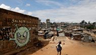 FILE PHOTO: A boy walks in front of a graffiti promoting the fight against the coronavirus disease (COVID-19) in the Mathare slums of Nairobi, Kenya, May 22, 2020. REUTERS/Baz Ratner/File Photo