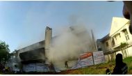 A fire brigade member runs away as three-story building collapses in Bangkok, Thailand April 3, 2021 in this still image obtained from a social media video. 