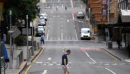 A man crosses a mostly empty city centre street as people in Greater Brisbane have been ordered into lockdown as authorities try to suppress a growing coronavirus disease (COVID-19) cluster in Brisbane, Australia, March 30, 2021. Picture taken March 30, 2