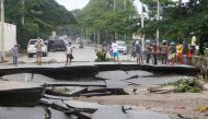 People stand near roads damaged by floods after heavy rainfall in Dili, East Timor, April 5, 2021. REUTERS/Lirio da Fonseca