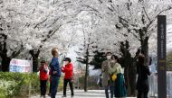 People walk near a cherry blossom street, closed to avoid the spread of the coronavirus disease (COVID-19), in Seoul, South Korea, April 1, 2021. REUTERS/Heo Ran