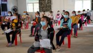 Garment factory workers and staff wait to receive China's Sinovac coronavirus disease (COVID-19) vaccine at an industrial park in Phnom Penh, Cambodia, April 7, 2021. REUTERS/Cindy Liu/File Photo