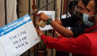Health workers attach a notice about the shortage of coronavirus disease (COVID-19) vaccine supplies at a vaccination centre in Mumbai, India, April 8, 2021. REUTERS/Francis Mascarenhas
