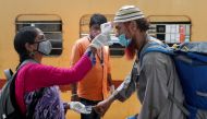 A health worker checks a passenger's temperature and pulse at a railway station platform amidst the spread of the coronavirus disease (COVID-19) in Mumbai, India, April 7, 2021. REUTERS/Francis Mascarenhas/File Photo