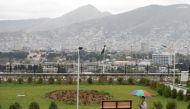 An Afghan man holds an umbrella as he walks on a rainy day on a hilltop overlooking Kabul, Afghanistan, April 15, 2021. Reuters/Mohammad Ismail